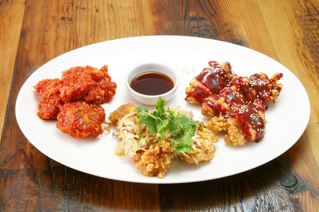 当店オリジナルの鶏唐揚げ3種ケイジャンチリソース、焼き葱油淋鶏、韓国風甘辛タレの盛り合わせ。